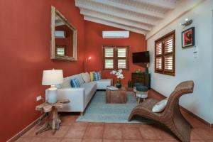 a living room with red walls and a white couch at Villa Adelaida in Palm-Eagle Beach