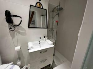 een witte badkamer met een wastafel en een spiegel bij 1B-Precioso Apartamento en pleno centro. A estreno in Alcazar de San Juan