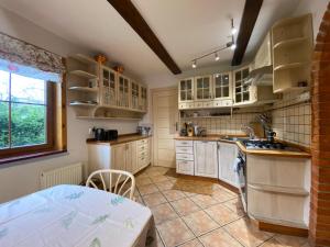 a kitchen with white cabinets and a sink and a table at Chata Sikorki 