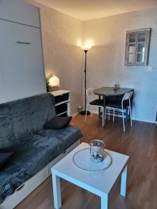 een woonkamer met een bank en een tafel bij Studio "Voile de nacre" in Bernières-sur-Mer