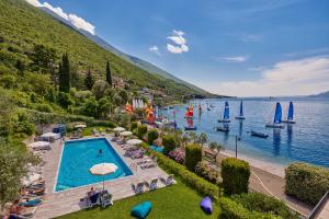 un complejo con una piscina junto a un cuerpo de agua en Beach Hotel Rosa, en Malcesine