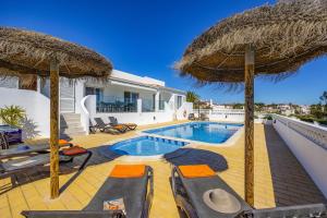 uma villa com piscina e 2 guarda-sóis em Villa Farol by Villa Plus na Praia do Carvoeiro