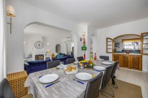 uma sala de jantar com uma mesa longa e cadeiras em Villa Farol by Villa Plus na Praia do Carvoeiro