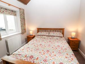 a bedroom with a bed with two night stands and two candles at The Flat in Carlisle