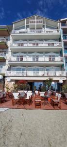 a building with tables and chairs in front of it at THEMIS BEACH in Paralia Katerinis