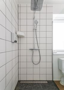 a shower in a bathroom with white tiles at Mount hotel in Slavske