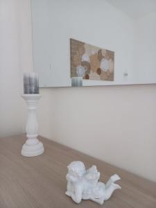 a white figurine sitting on a floor next to a candle at Civico 26 T in San Salvo