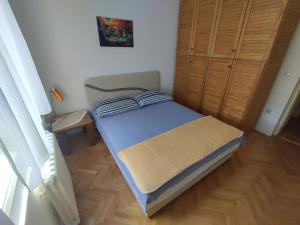 um pequeno quarto com uma cama e um closet em Woody em Novi Sad