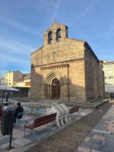 an old brick building with tables and benches in front of it at La Estación in Avilés