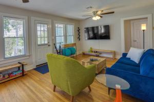 a living room with a blue couch and a table at Vibrant Fayetteville Home - Walk Downtown! in Fayetteville