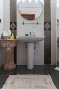 a bathroom with a sink and a mirror and a rug at Casa Martina in Alexandroupoli