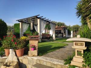 a backyard with a pergola and a stone wall at Casa Martina in Alexandroupoli