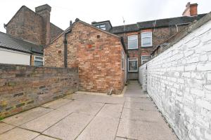 an alley with a brick wall and a building at Clarice House by YourStays in Etruria