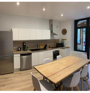 a kitchen with a wooden table and white cabinets at Le Perchoir- Grand Valtin 6 pers in Ban-sur-Meurthe-Clefcy