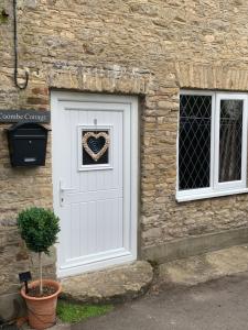 a door with a heart wreath on it at Cotswold Coombe Cottage in Wotton-under-Edge