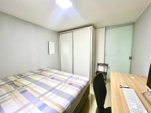 a small bedroom with a bed and a desk at Kit asa norte in Brasilia