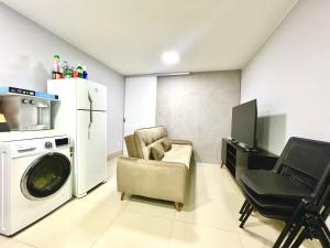 a living room with a washing machine and a chair at Kit asa norte in Brasilia