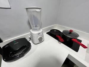 a counter with a blender and a pot on it at Kit asa norte in Brasilia