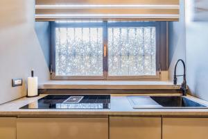 une cuisine avec un évier et une fenêtre dans l'établissement Bligny Studio 4PAX WIFI Bocconi District, à Milan