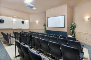 una sala de conferencias con sillas negras y una pantalla en LUXURIOUS CONDO - JUST 2 MILES FROM DISNEY #404 en Orlando