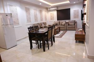 ليوان الخليج للوحدات السكنية المفروشة في الرياض: مطبخ وغرفة طعام مع طاولة وثلاجة