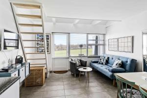 un soggiorno con un divano blu e un tavolo di Bornholm Holiday Apartment With Sea View ad Allinge