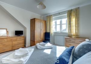 1 dormitorio con 1 cama y TV en Scholars Cottage en Reydon