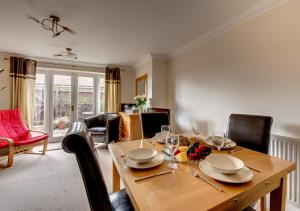 a dining room with a wooden table and chairs at Scholars Cottage in Reydon