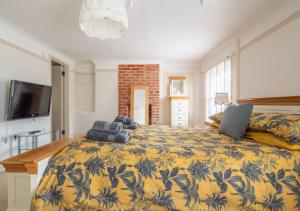 a bedroom with a bed with a yellow and blue blanket at Kiln House in Snape