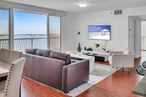 a living room with a couch and a tv at Ocean View Amazing Unit Brickell in Miami