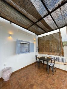 a patio with a table and chairs and a window at Theros - Traditional House in Psinthos in Psinthos