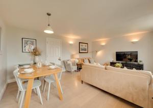 uma sala de estar com um sofá e uma mesa em 2 Truman Lodge em Thorpeness