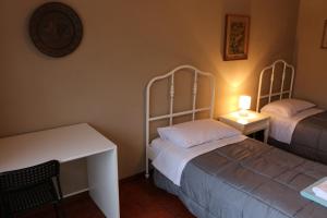 a room with two beds and a table and a desk at EasyRoom Schio in Schio