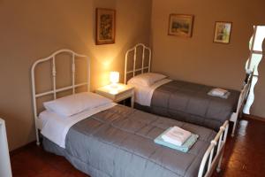 a bedroom with two beds and a lamp on a table at EasyRoom Schio in Schio