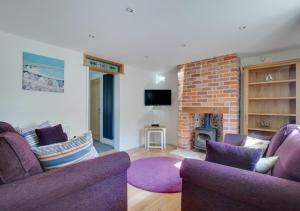 a living room with two purple chairs and a fireplace at Friday Place in Middleton