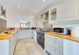 a kitchen with white cabinets and a stove top oven at The Cartlodge in Sudbury