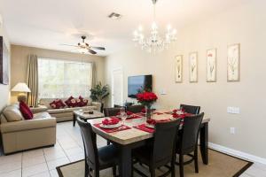 a dining room and living room with a table and chairs at Fantastic Condo - 2 Miles from Disney Pool View Windsor Hills in Orlando