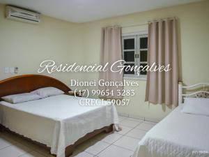 1 dormitorio con 2 camas y un cartel que lee condominios residenciales de hormigón en Residencial Gonçalves I, en Bombinhas