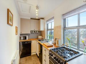 a kitchen with a stove top oven next to a window at Mill Cottage in Clitheroe