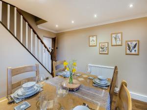 a dining room with a table with glasses and flowers on it at Mill Cottage in Clitheroe
