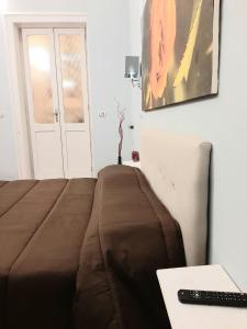 un letto con una coperta marrone accanto a un tavolo di Dimora " Le Rose " a Lecce