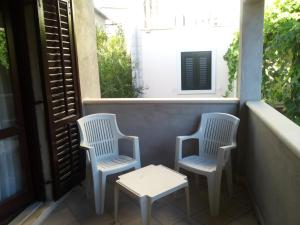 two chairs and a table on a balcony at Apartment Ranka in Postira