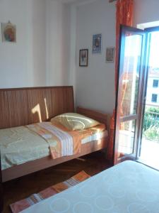 a bedroom with a bed and a sliding glass door at Apartment Ranka in Postira
