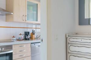 a kitchen with white cabinets and a white dishwasher at Chalet con Impresionantes vistas en Conil in Conil de la Frontera