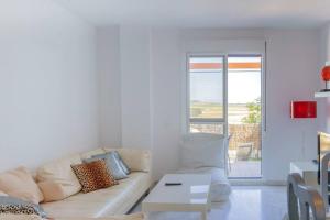 a white living room with a couch and a table at Chalet con Impresionantes vistas en Conil in Conil de la Frontera