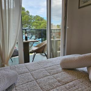 a bedroom with a bed and a view of a balcony at Apartman River Breeze in Omiš