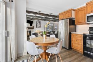 a kitchen with a wooden table and white chairs at Collingwood Chalet Near Blue Mountain Slopes 39B in Collingwood
