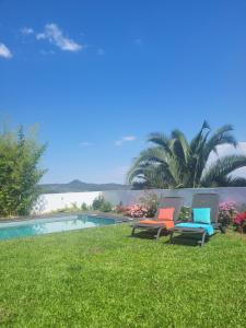 dos sillas sentadas en el césped junto a una piscina en Alijó Douro House, en Alijó
