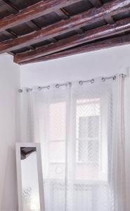 espejo frente a una ventana con cortinas en Stranamore Apartments Trastevere, en Roma