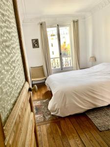 a bedroom with a white bed and a window at Love Nest In Paris in Paris